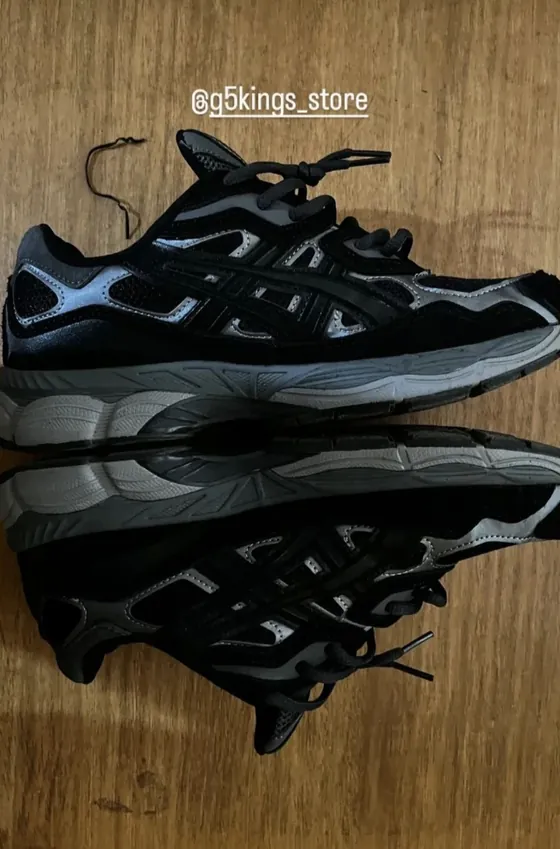 Asics negras con gris sobre una mesa de madera