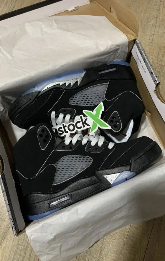 Jordan 5 negras en su caja con sticker de StockX