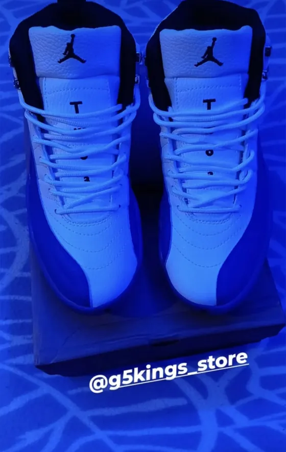 Jordan 12 blanco con azul sobre su caja